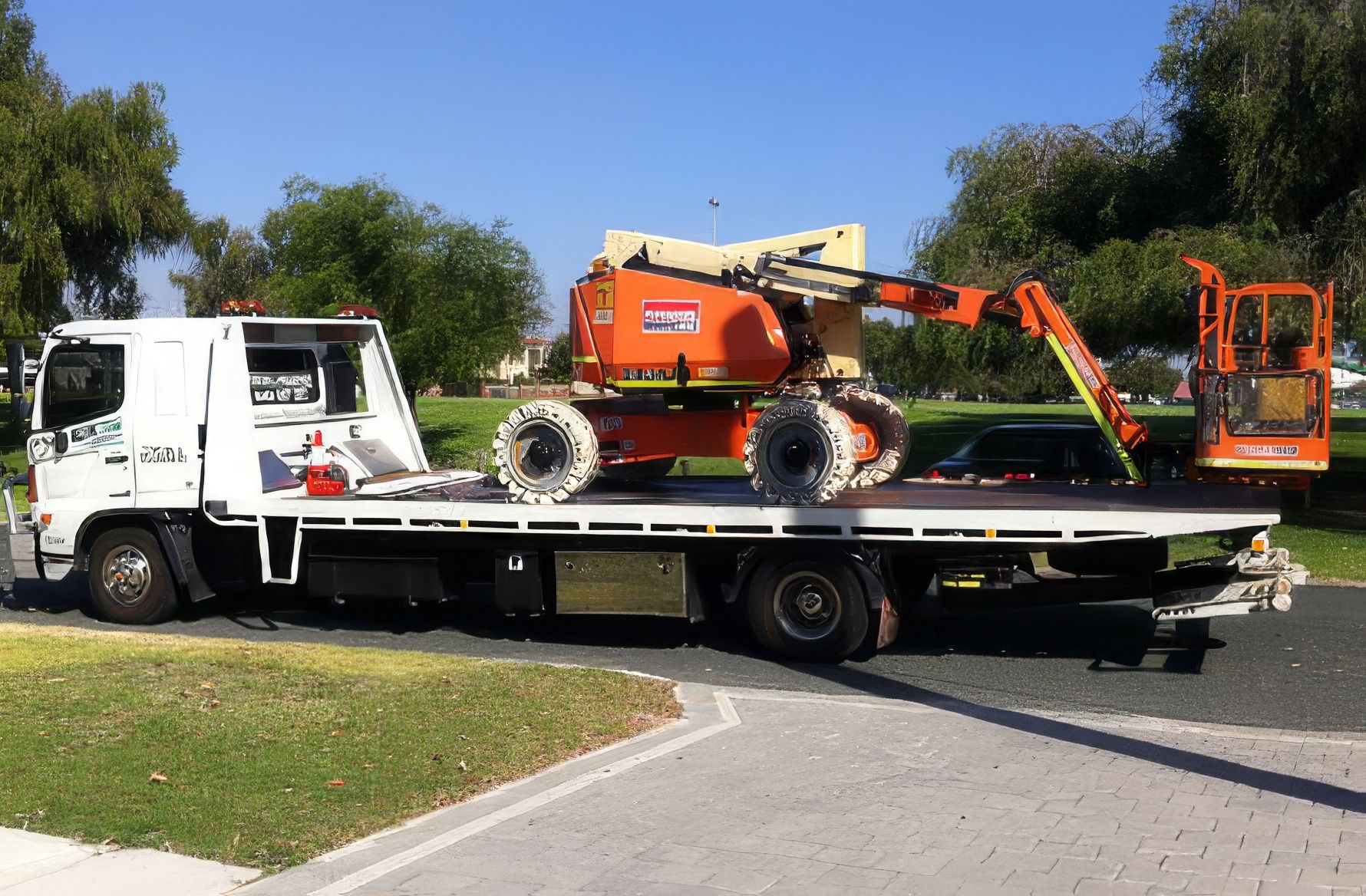 Boom lift machinery being transported on a Quik Tow tilt tray truck in Perth